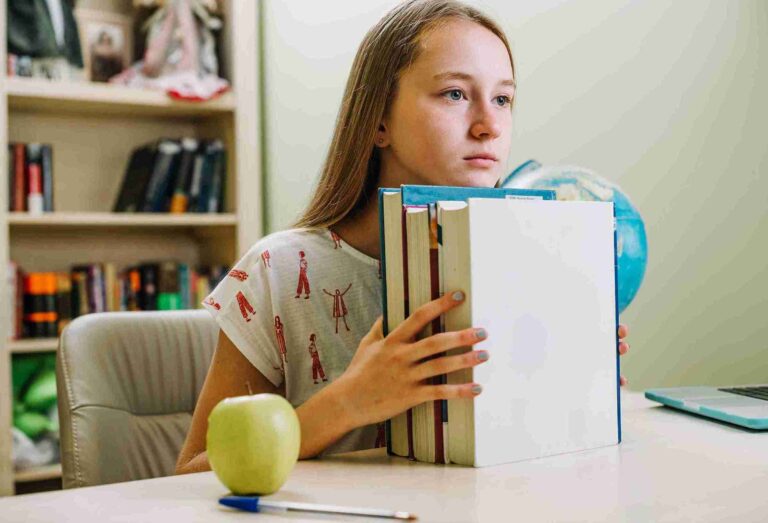 Student holding books during science revision.